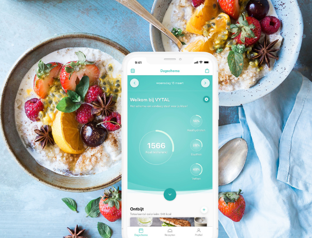 Telefoon met Vytal app zichtbaar met op de achtergrond voeding